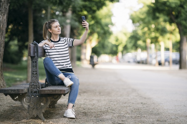 kobieta robiaca selfie na smartfonie siedzac