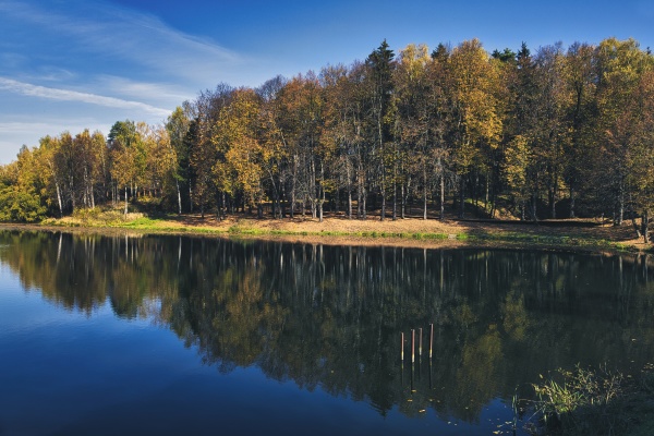 blyszczace jezioro odbijajace otaczajacy jesienny las